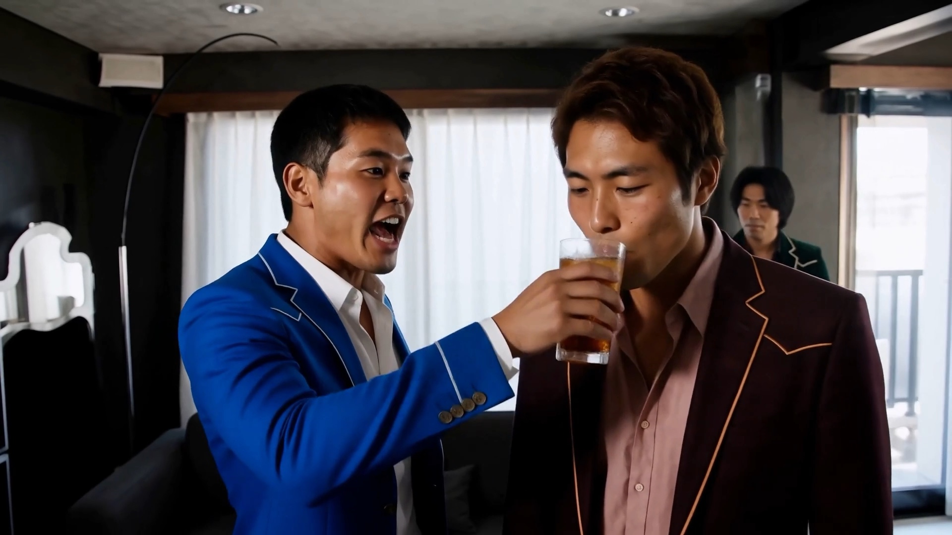 青いスーツの主人公の隣でえんじ色のスーツの人物が茶色い飲み物のグラスを口元に運ぶ